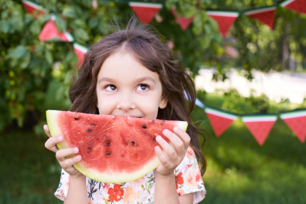 수 분이 많은 빨간 수 박 쪼 갠 다입니다. 작은 소녀. 밝은 잔디. 여름 화창한 날 - picnic watermelon summer food 뉴스 사진 이미지