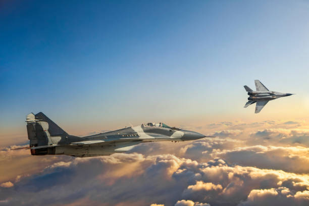 Mig-29 Fighter Jets in Flight over the clouds at sunset stock photo