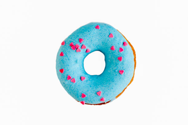 istock Blue donut sprinkled with small pink hearts on white isolate background 955032098