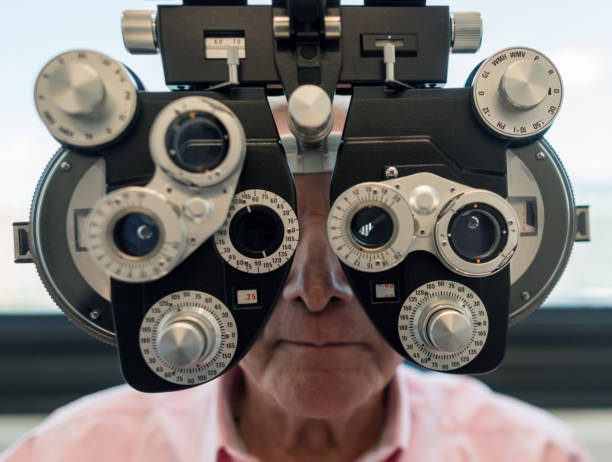 istock Senior patient looking through the phoropter at an opthalmologist consult 955034068
