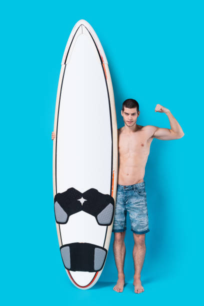 istock Surfer holding a surfboard showing his power 955037598