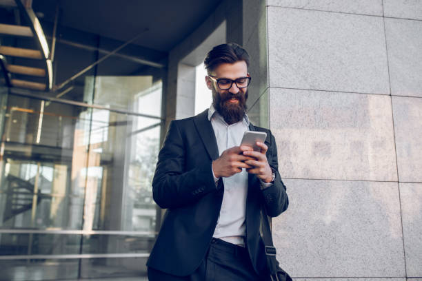 istock Young businessman reading text message on mobile phone 955040418