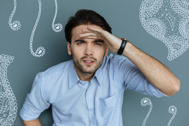 istock Good looking man being in searching process with a hand on his forehead 955040572