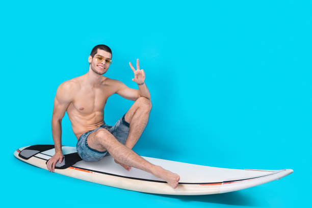 istock Cheerful surfer showing victory sign 955040774