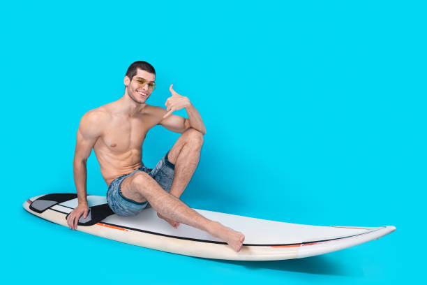 istock Cheerful surfer showing call me sign 955040808
