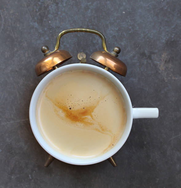Cup of coffee and vintage alarm clock