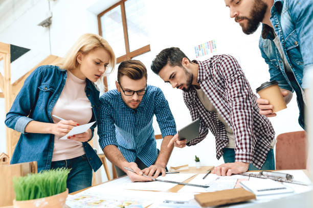 istock Team of designers architects draw on blueprint. 955044360