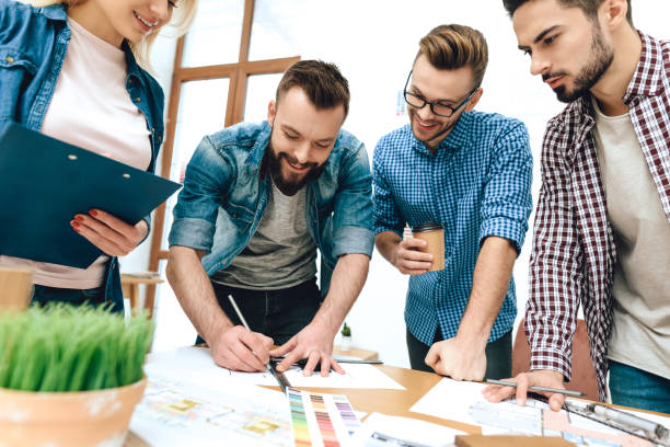 istock Team of designers architects draw on blueprint. 955044588