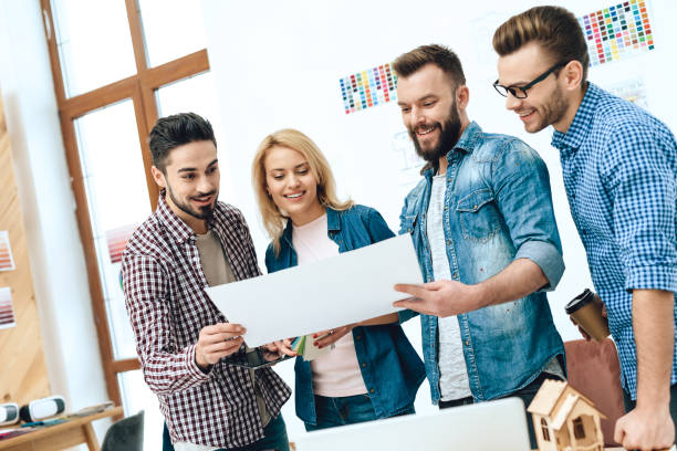 istock Team of designers architects look at blueprint. 955044740