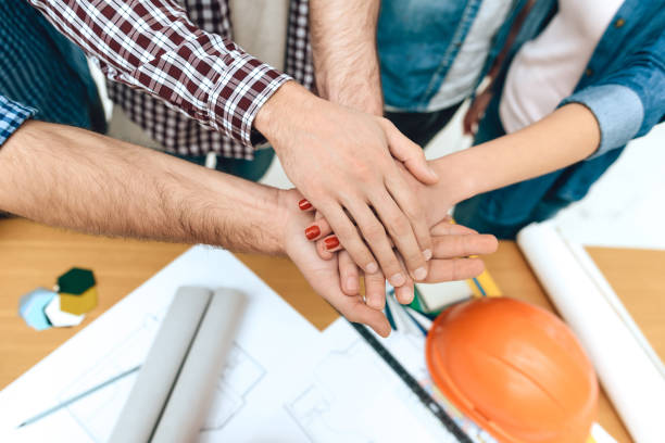 istock Close up team of designers architects hold hands. 955044792