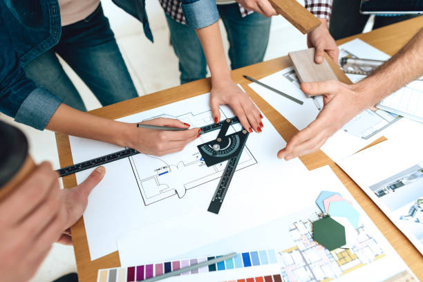 istock Team of designers architects draw on blueprint. 955045224