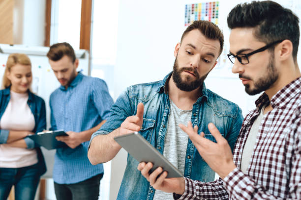 istock Team of designers architects look at tablet. 955047420