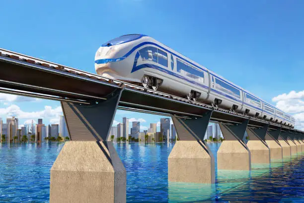 High speed modern train on the railroad bridge through the water landscape and the city on the horizon