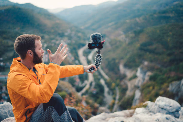 istock Tourist hiking and vlogging on the mountain top 955060182