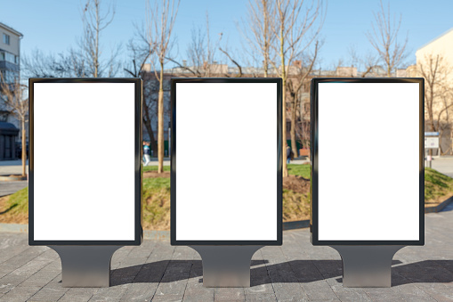 Three blank street billboard poster stand on sidewalk
