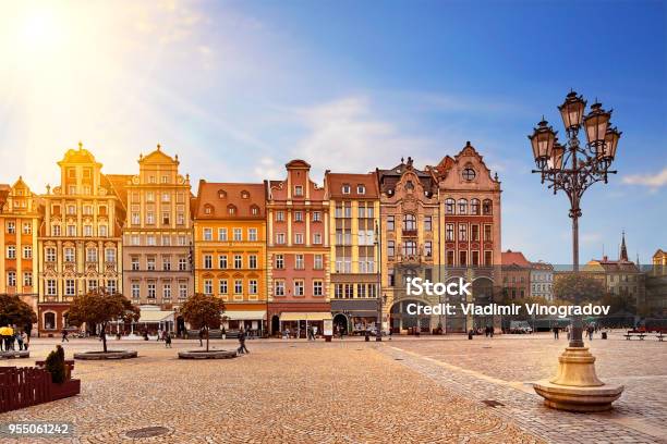 Photo libre de droit de Place Du Marché Central De Wroclaw Pologne Avec Vieilles Maisons Colorées Lampe De Rue Lanterne Et À Quelques Touristes Personnes Au Magnifique Superbe Soleil Lever Du Soleil De Matin Concept De Vacances Voyage banque d'images et plus d'images libres de droit de Cracovie