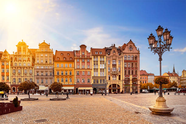 piazza centrale del mercato a breslavia in polonia con vecchie case colorate, lampione per lanterne da strada e turisti che camminano persone in uno splendido sole mattutino all'alba. concetto di vacanza di viaggio - gdansk foto e immagini stock