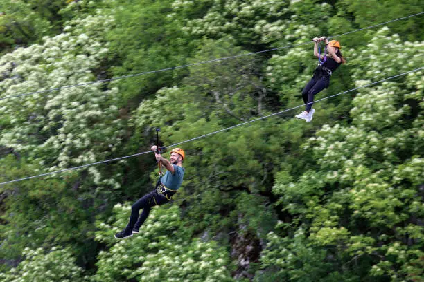 Young couple having fun on zip line. Both Caucasian people.