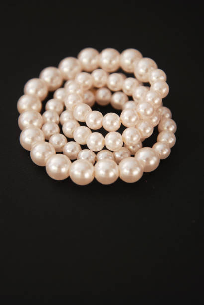 istock White String Pearls necklace, isolated on black Copy space 955079182