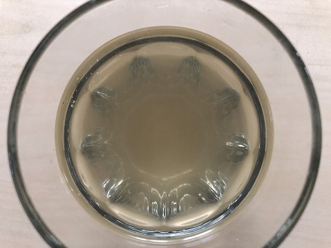 Healthy apple cider vinegar drink in a plain drinking glass viewed from above