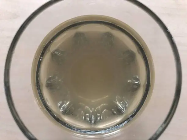 Healthy apple cider vinegar drink in a plain drinking glass viewed from above