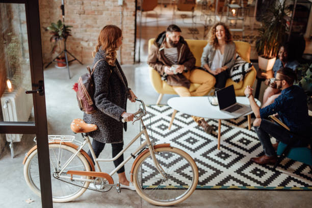 Close up of a woman entering office with bicycle Close up of a woman entering office with bicycle hipster culture stock pictures, royalty-free photos & images