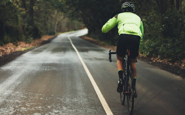 radfahrer, die sich darin üben, an einem regnerischen tag - racing bicycle cycling professional sport bicycle stock-fotos und bilder