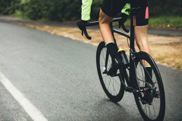 istock Athlete cycling on country road 955084722