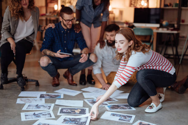 istock Creative people looking at project plans laying on floor 955085464