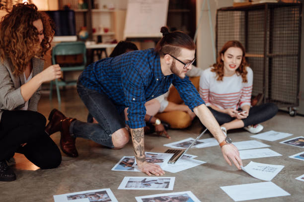 istock Creative people looking at project plans laying on floor 955085660