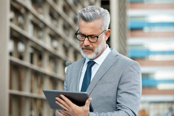 istock Confident businessman using digital tablet in city 955088890