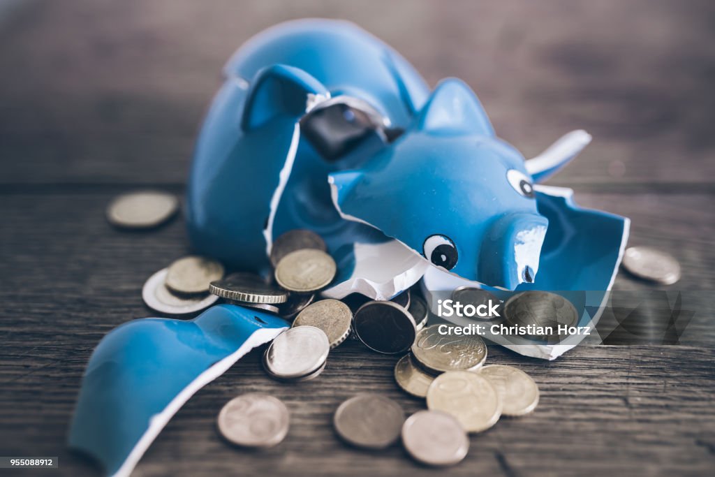 shattered broken piggy bank with coins on rustic wooden table closeup of shattered broken piggy bank with coins on rustic wooden table Bankruptcy Stock Photo