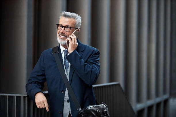 istock Businessman smiling while using phone in city 955088932