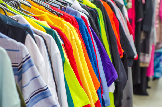 istock Multicolored old clothes on the hangers in the store 955089270