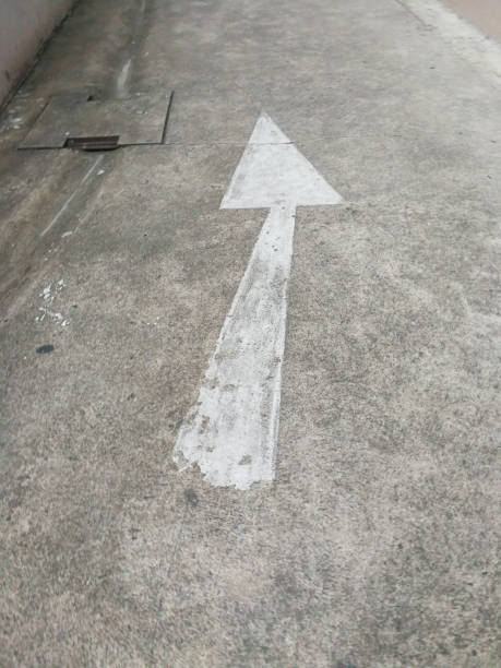 istock Arrow sign on the old asphalt road 955092184