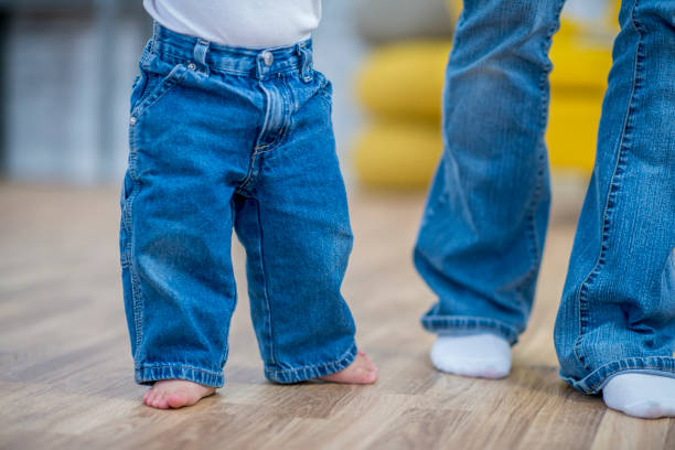 istock Legs of a baby learning to walk with his mom 955095866