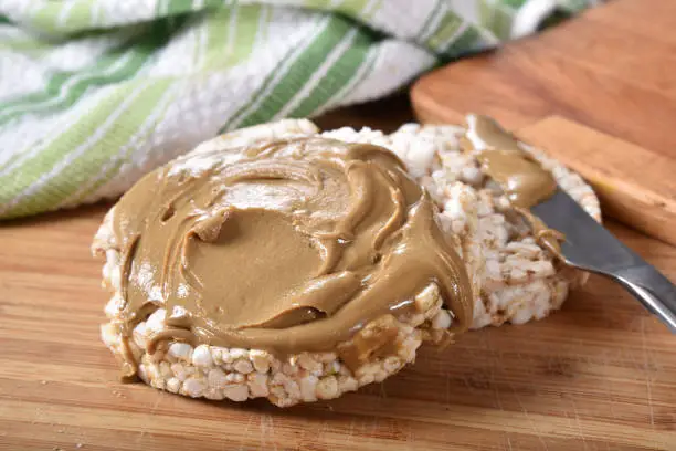 Brown puffed rice cakes with creamy peanut butter.