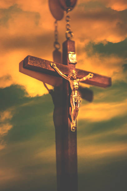 istock Crucifix with part of rosary on the sky background 955105032
