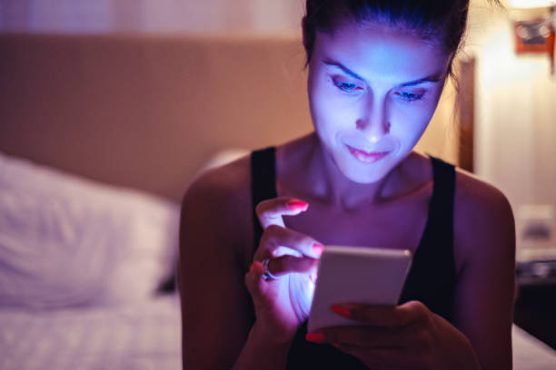 Girl looking at mobile phone in the bedroom Girl looking at mobile phone in the dimmed bedroom bicycle light photos stock pictures, royalty-free photos & images
