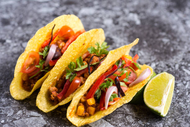 istock Three Colorful Mexican Tacos in Shells on Stone Background 955109552