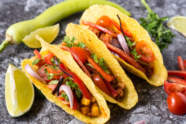 istock Three Colorful Mexican Tacos in Shells on Stone Background 955112930