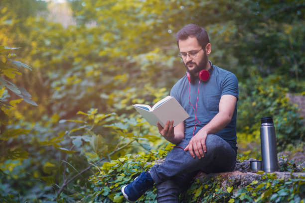 détente et de lecture homme de boire du thé en plein air - the thinker audio photos et images de collection