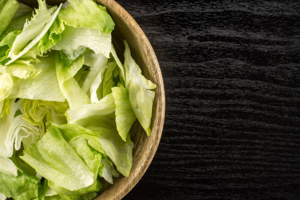 istock Fresh Raw Iceberg Lettuce on black wood 955116770
