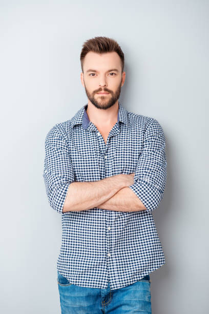 istock Stylish modern guy with crossed hands isolated on gray background 955117368
