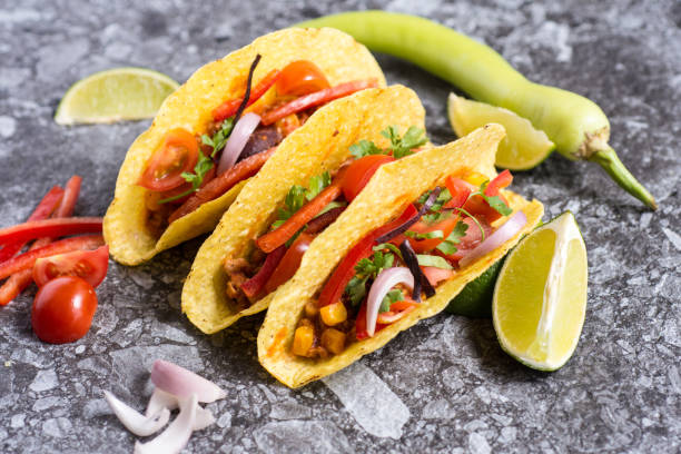 istock Three Colorful Mexican Tacos in Shells on Stone Background 955117658