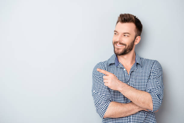 istock Cheerful handsome man showing direction and pointing with finger 955117662