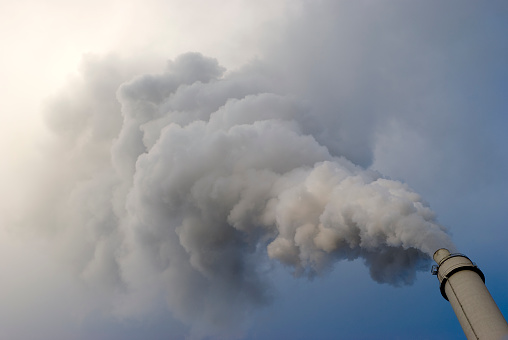 dramatic smoking chimney on blue sky, air pollution