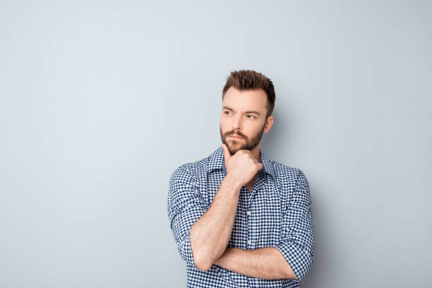istock Handsome ponder young businessman isolated on gray background 955119820
