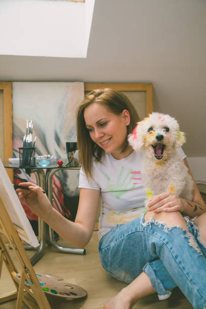 istock Happy young woman paints on canvas 955120166