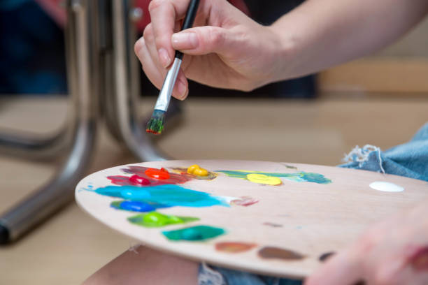 istock Happy young woman paints on canvas 955120190